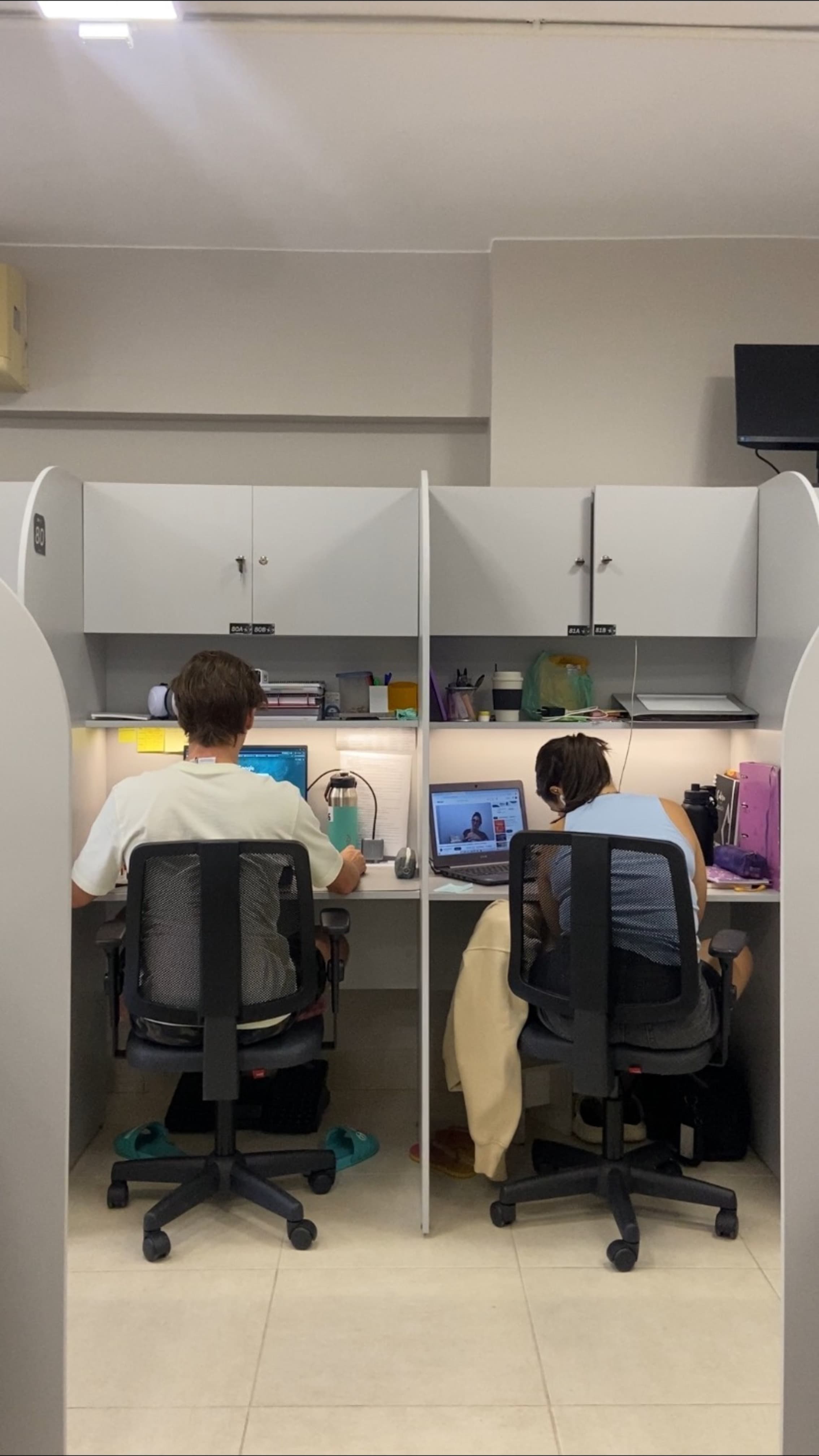 Dois clientes nas cabines fixas trabalhando com notebooks