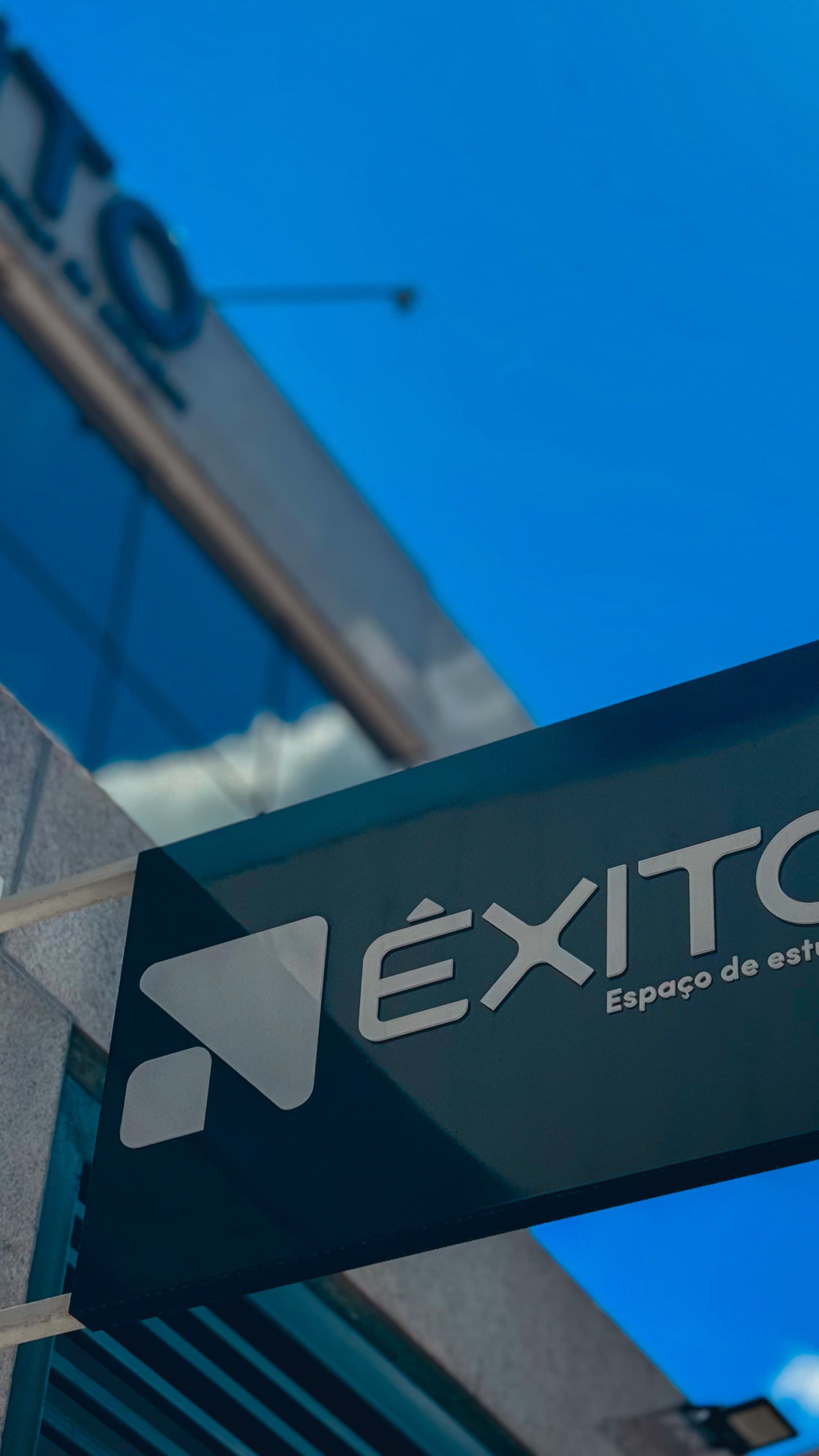 Placa suspensa Êxito vista de baixo com céu azul vibrante